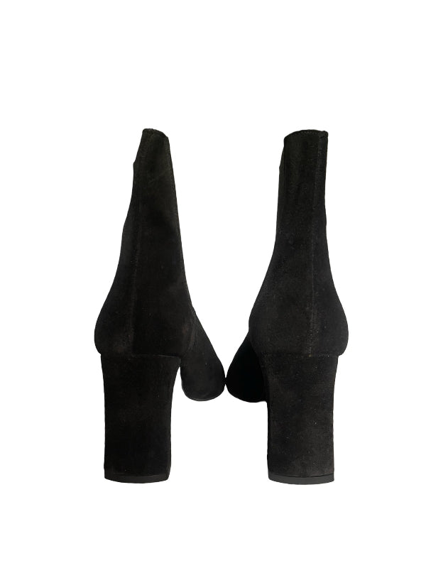 A pair of black suede ankle boots with block heels, shown from the back against a plain white background.