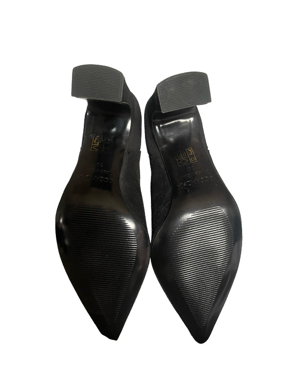 A pair of black pointed-toe heels shown from the bottom, displaying the soles and heel caps, on a plain white background.