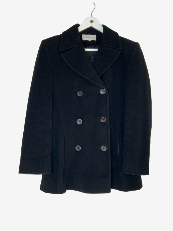 A black double-breasted coat with wide lapels and dark buttons, hanging on a white hanger against a light gray background.