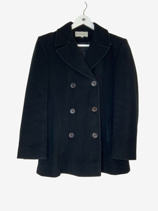 A black double-breasted coat with wide lapels and dark buttons, hanging on a white hanger against a light gray background.