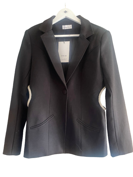 A black tailored blazer jacket with notched lapels, a single front button, and two front flap pockets, hanging on a white hanger against a plain white background. Decorative metallic trim accents are visible along the curved side seams.