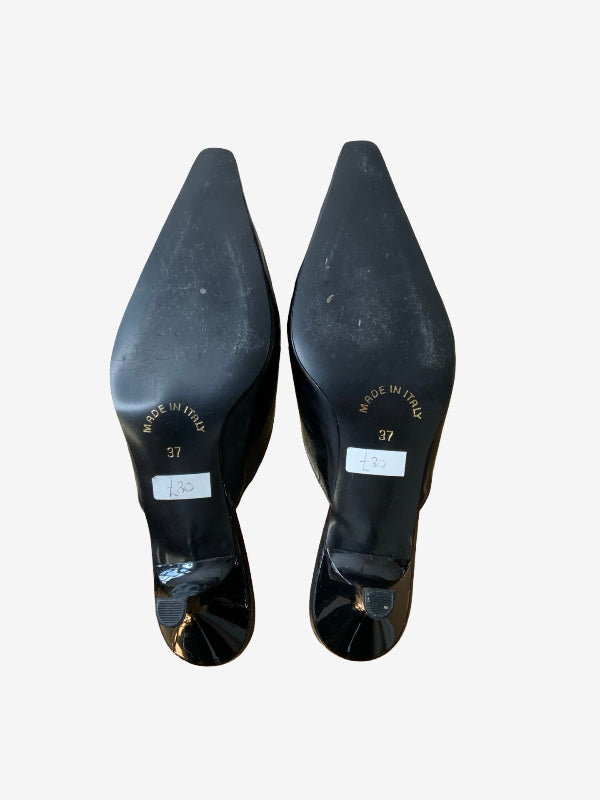 A pair of black pointed-toe heels shown from the sole side against a plain light gray background.