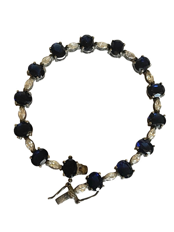 A vintage-style tennis bracelet featuring round dark blue cabochon gemstones and marquise-cut clear crystals set in silver-toned metal, shown against a plain white background.
