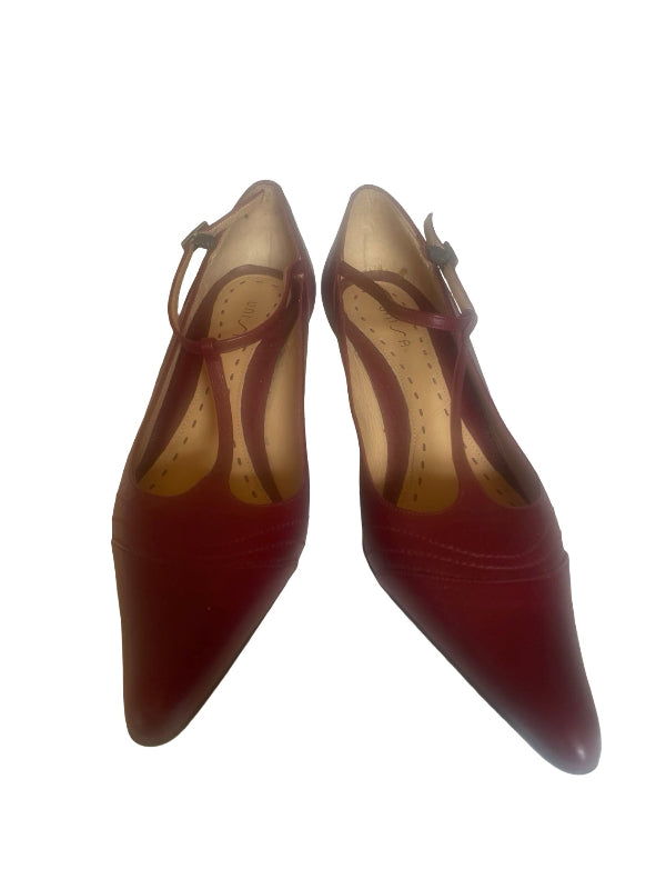 A pair of women's pointed-toe pumps in a deep burgundy red, featuring thin ankle straps with small buckle details and a beige insole, shown against a plain white background.