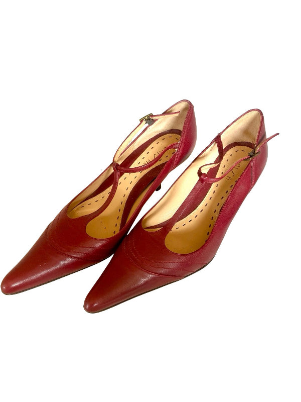 A pair of red leather pointed-toe Mary jane T bar  pumps with a tan insole, displayed on a clean white background.