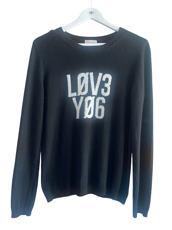 A black long-sleeve crewneck sweater hanging on a white plastic hanger, featuring the text 'LOV3 YD6' printed in distressed white block letters on the front.