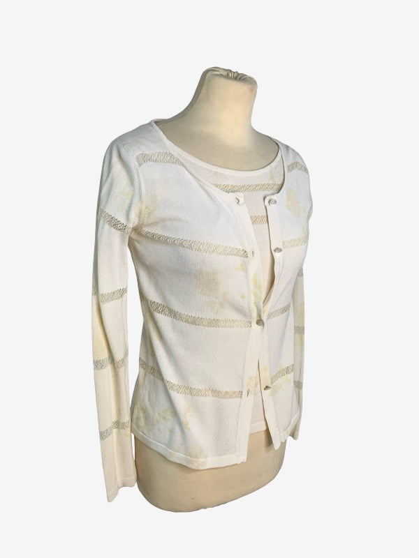 A cream-colored knit cardigan with horizontal cut out sheer stripes, displayed on a beige mannequin torso against a light gray background.