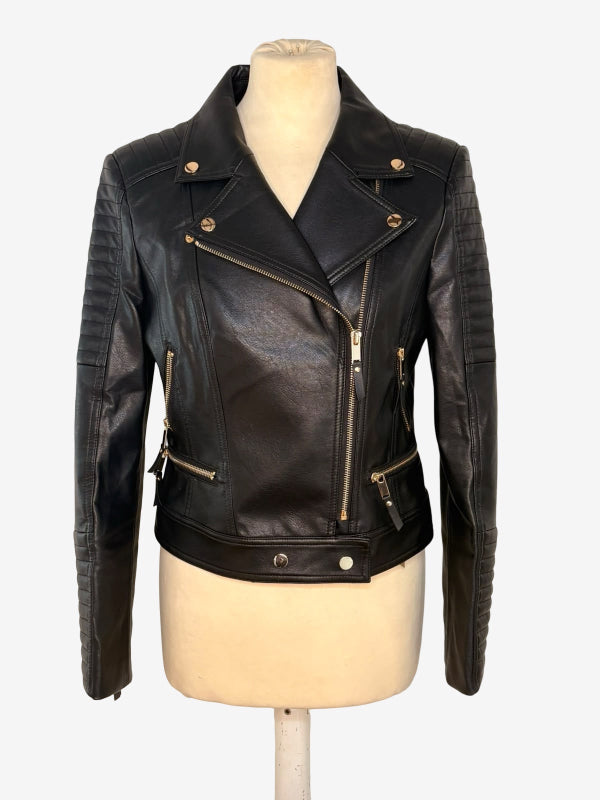 Black leather moto jacket with asymmetrical zipper, ribbed sleeves, and gold-tone hardware, displayed on a cream mannequin torso against a light gray background.