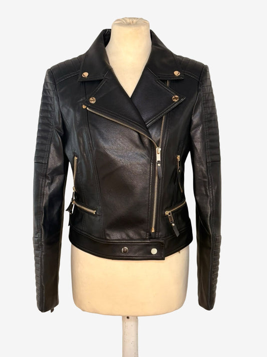 Black leather moto jacket with asymmetrical zipper, ribbed sleeves, and gold-tone hardware, displayed on a cream mannequin torso against a light gray background.