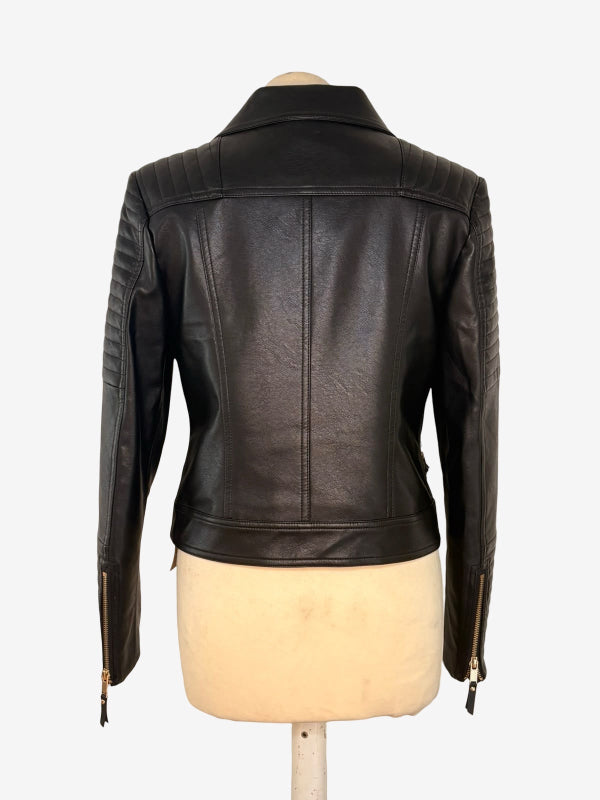 Black leather motorcycle jacket shown from the back on a cream-colored dress form mannequin, against a plain white background.