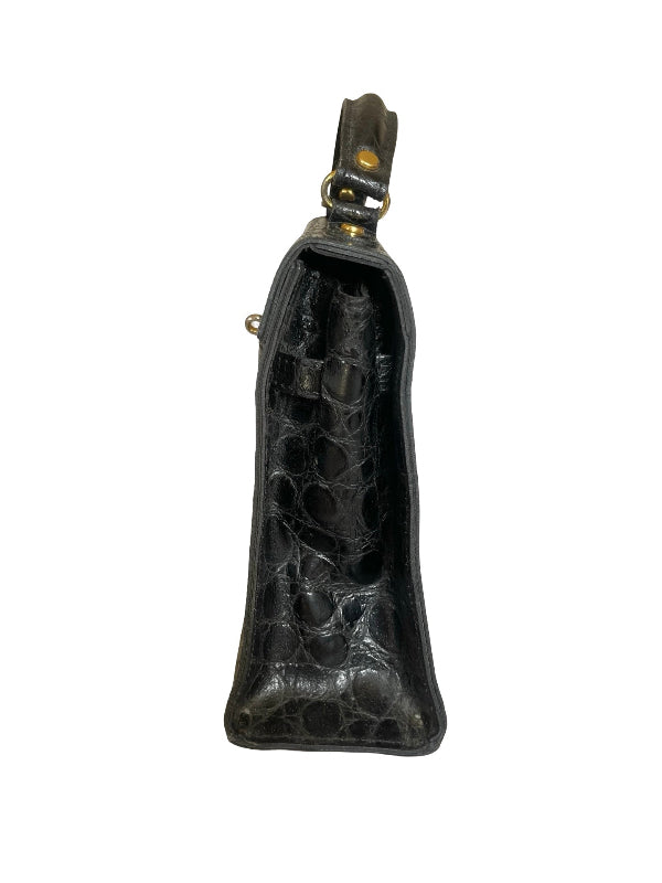 A black crocodile-embossed leather pouch with gold-tone metal hardware, shown from the front against a plain white background.