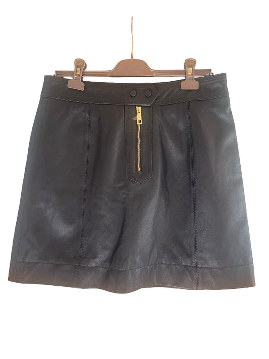 A black leather mini skirt with a gold zipper detail  at the front, hanging on a wooden hanger against a white background.