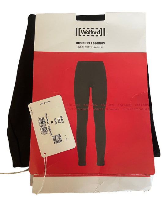 A pair of black business leggings folded and packaged in a red and white Wolford box with a hanging size tag.