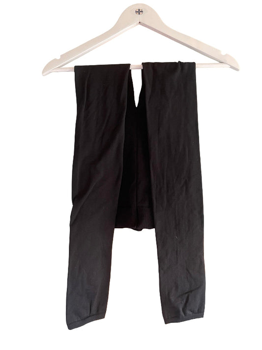 Black leggings pants hanging on a white wooden hanger against a plain white background.