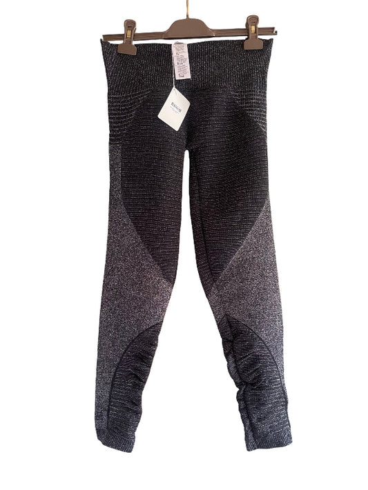 A pair of women's knit leggings in a heathered black and gray color-blocked design, hanging from a brown wooden hanger with tags attached against a plain white background.