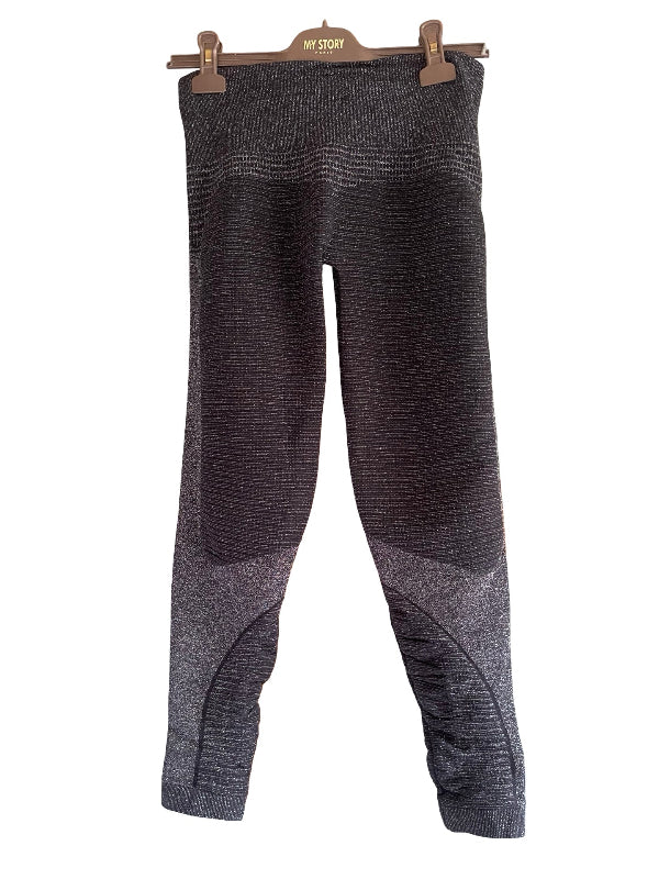 Dark gray textured knit leggings with lighter gray contrast panels on the lower legs, hanging from a wooden hanger