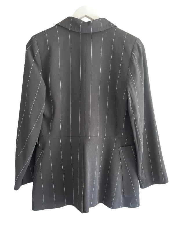 A black pinstripe blazer jacket with long sleeves and flap pockets, shown from the back on a white hanger against a white background.