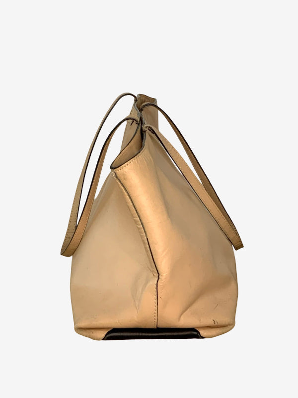 A blush leather shoulder bag with a slouchy, bucket-like silhouette and thin straps, shown against a plain light gray background.