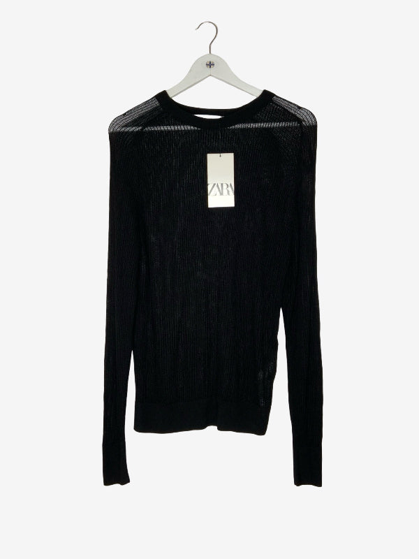 A black long-sleeve ribbed knit sweater with sheer mesh shoulder panels, hanging on a white hanger with a visible Zara tag, against a plain white background.