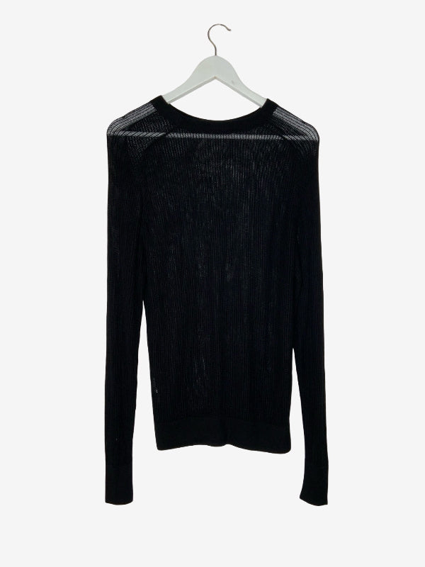 A black long-sleeve knit sweater with a textured ribbed pattern and sheer mesh shoulder panels, hanging on a white hanger against a light gray background.